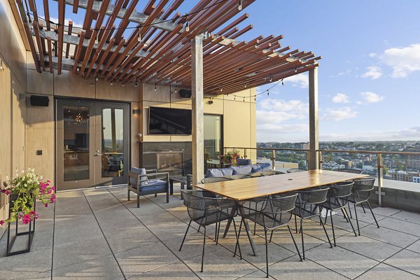 Spacious patio with stylish seating at Vela on The Park Apartments offering cityscape views