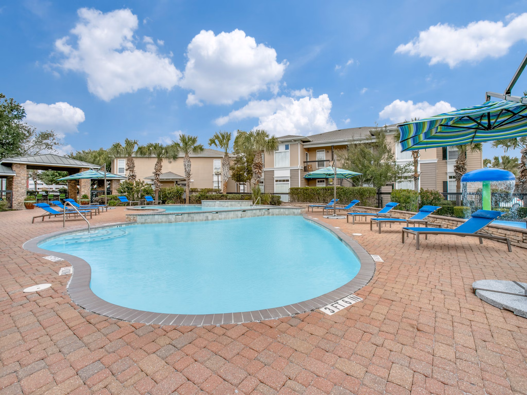 Luxurious resort-style pool at Westmount at Mason Creek Apartments featuring poolside cabanas and lush landscaping