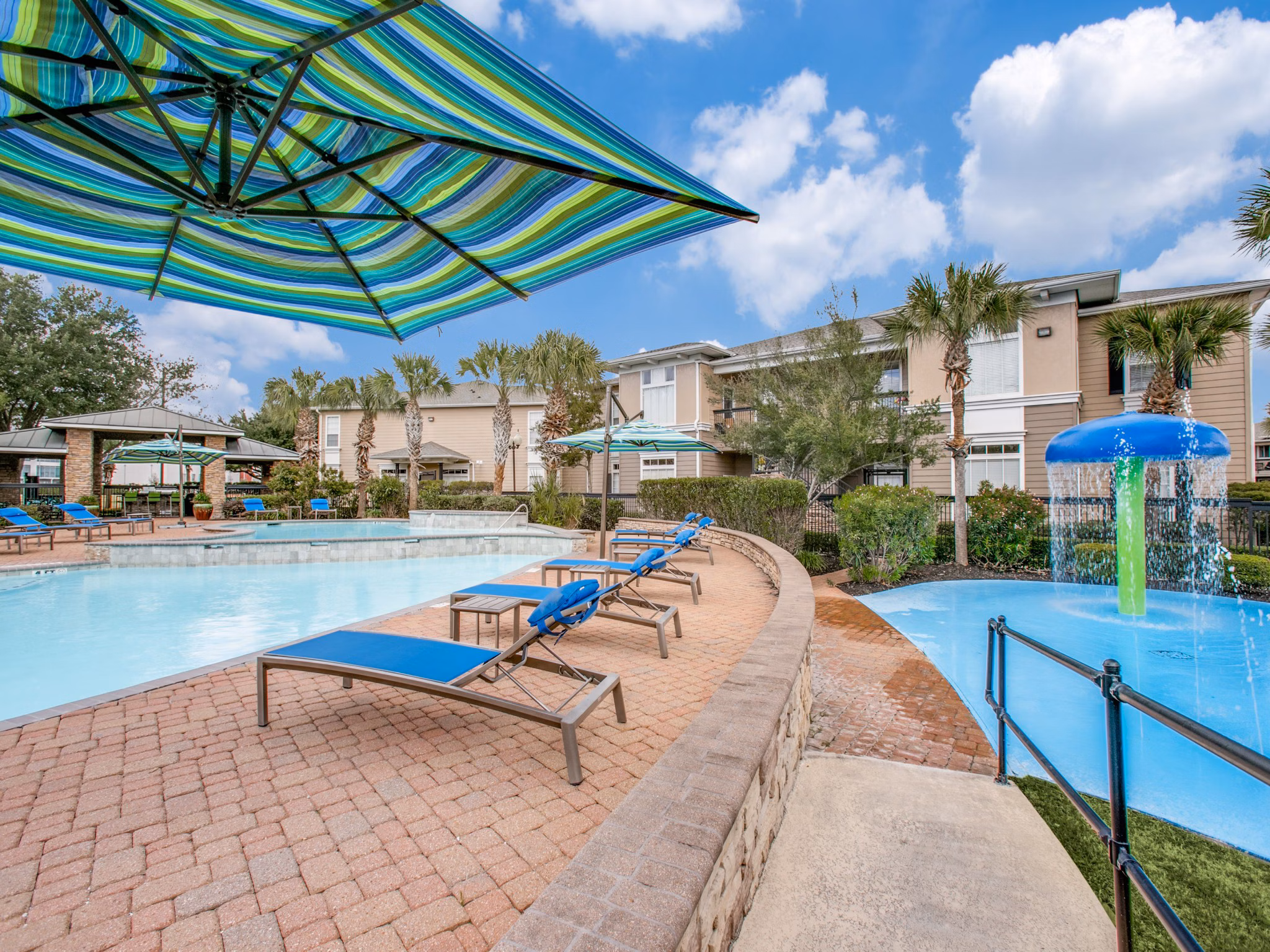 Outdoor leisure pool surrounded by lush landscaping at Westmount at Mason Creek Apartments offering relaxation and recreation in a serene setting