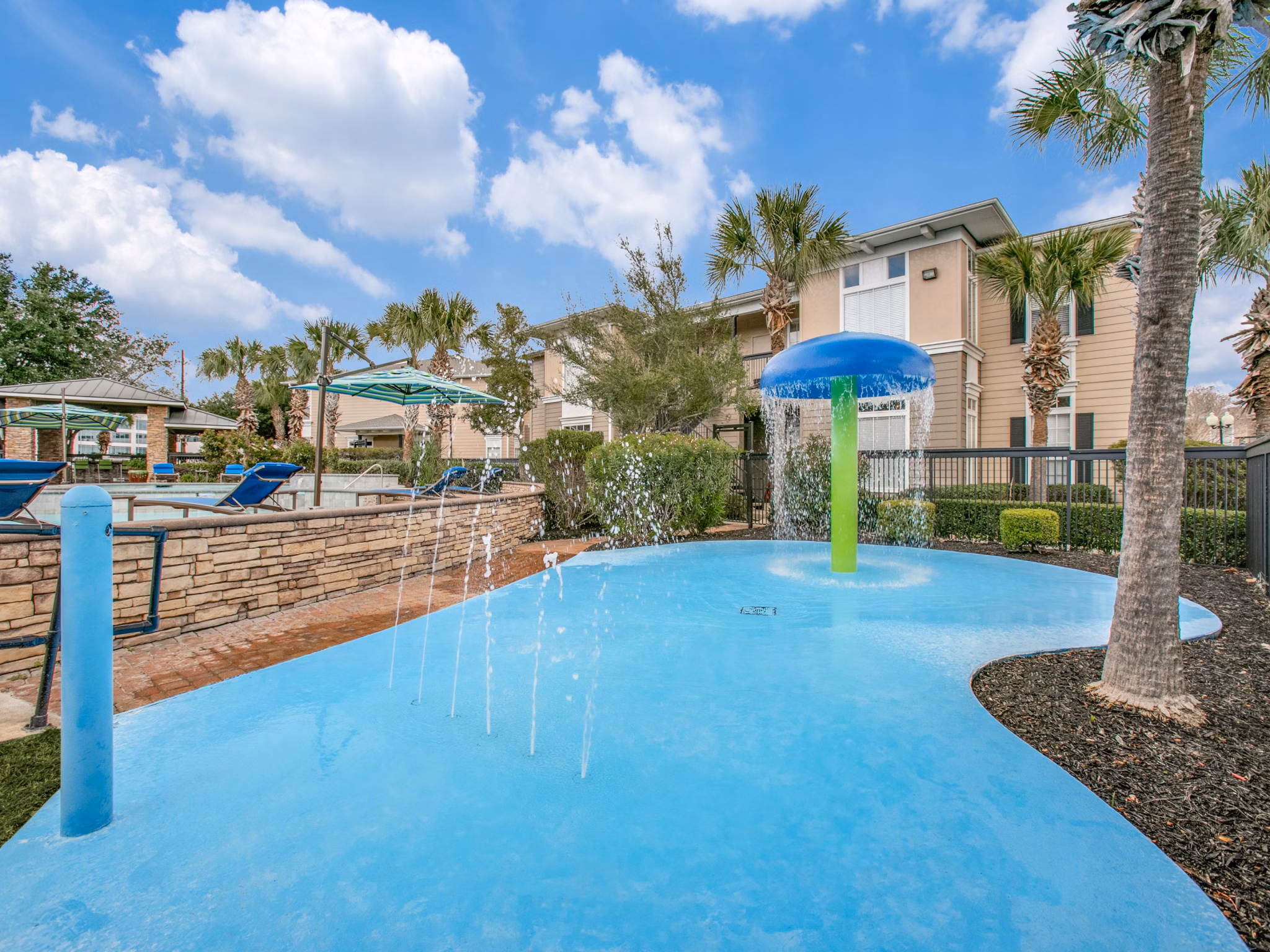 Relaxing poolside area with sun loungers at Westmount at Mason Creek Apartments