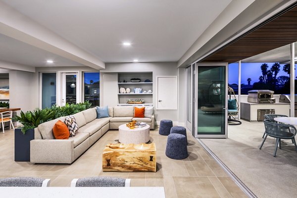 Cora Apartments: Modern clubhouse with cozy seating areas and bright decor in a vibrant community