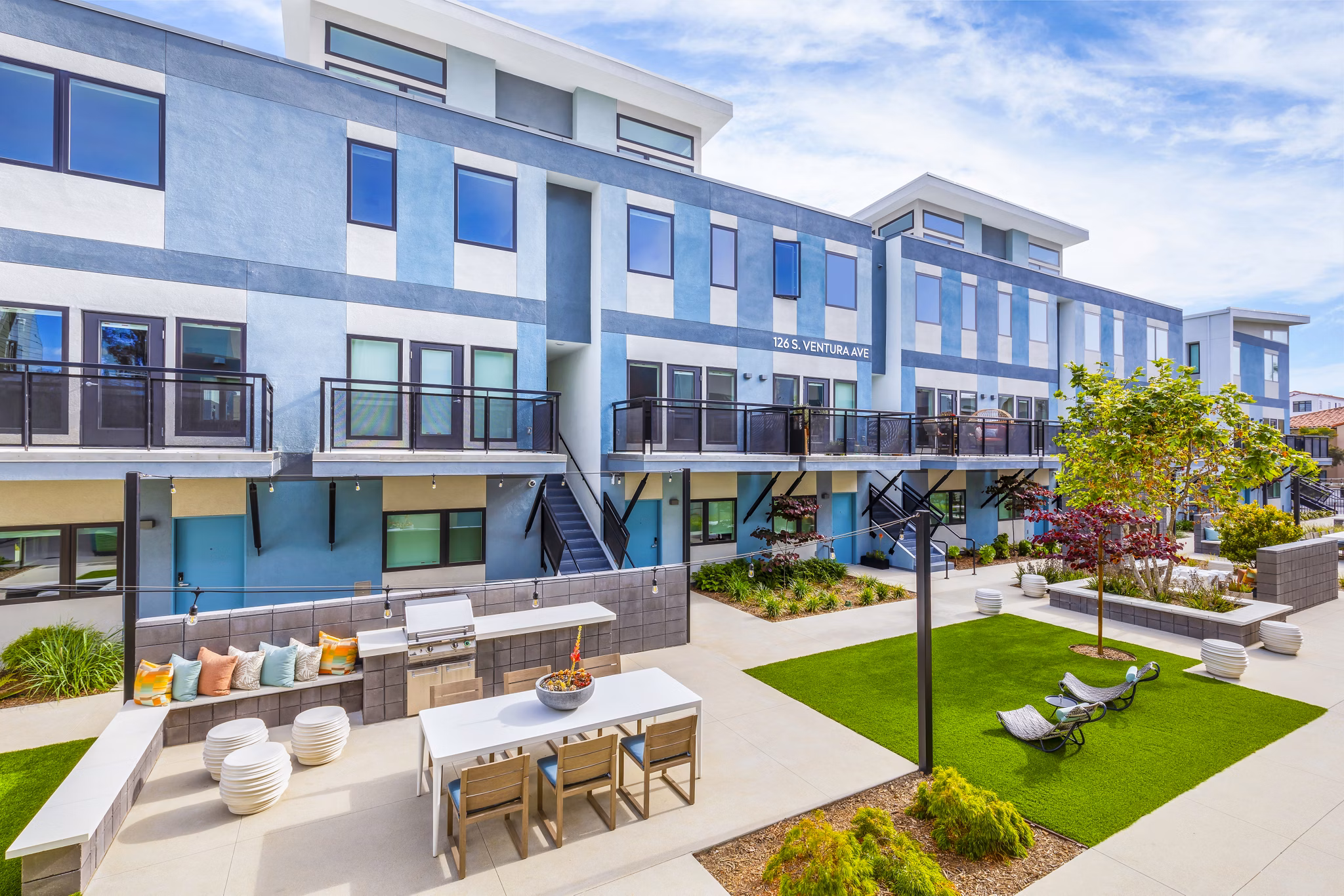Outdoor grill area on patio with modern seating at Cora Apartments