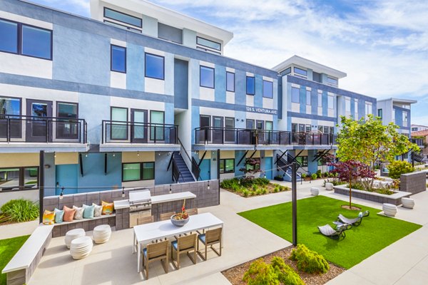 Outdoor grill area on patio with modern seating at Cora Apartments