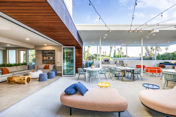 Outdoor grill area and patio at Cora Apartments offering stylish relaxation and dining space