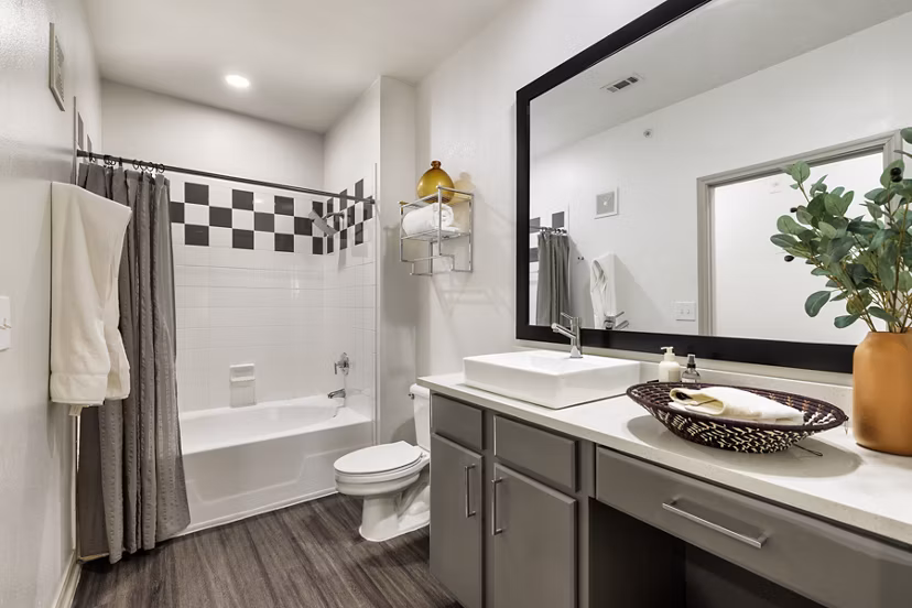 Modern bathroom featuring sleek fixtures and large mirror in Muse at SoCo Apartments luxury living