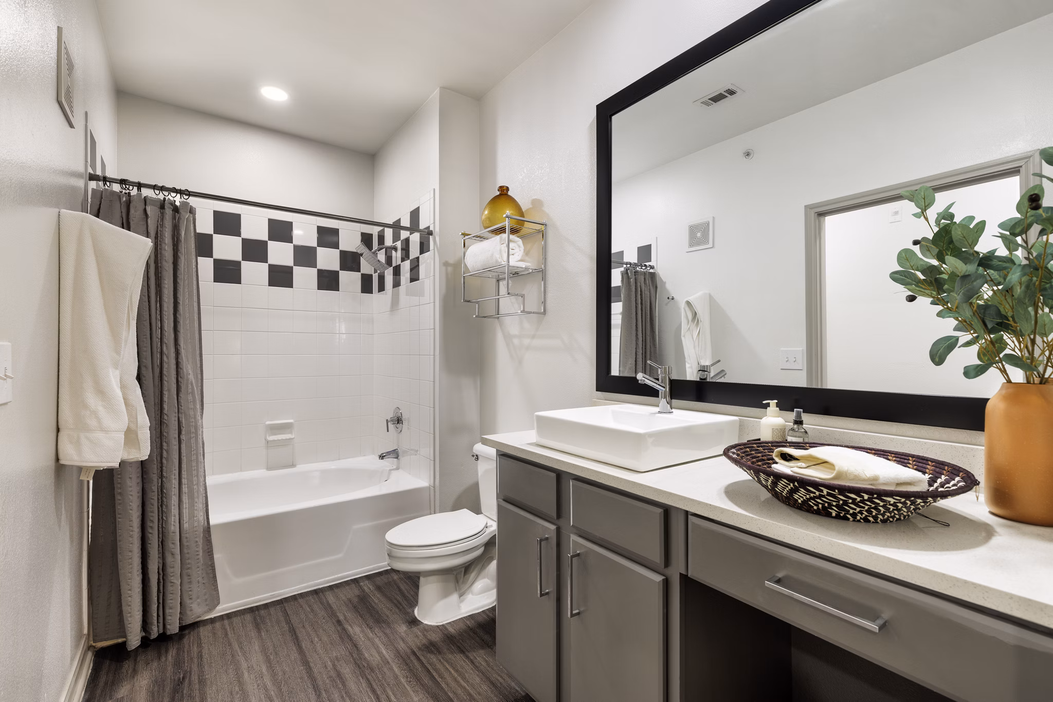 Modern bathroom featuring sleek fixtures and large mirror in Muse at SoCo Apartments luxury living