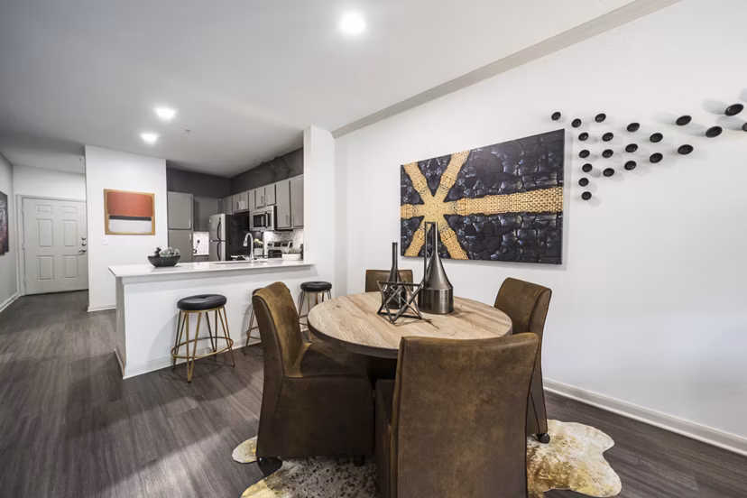 Modern dining area featuring elegant wood table and pendant lighting at Muse at SoCo Apartments, ideal for luxury living in Austin