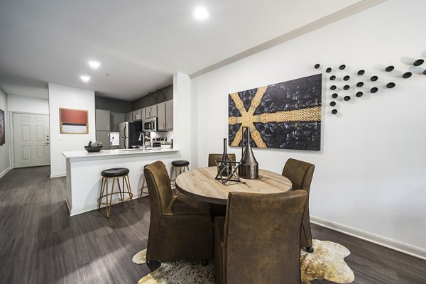 Modern dining area featuring elegant wood table and pendant lighting at Muse at SoCo Apartments, ideal for luxury living in Austin