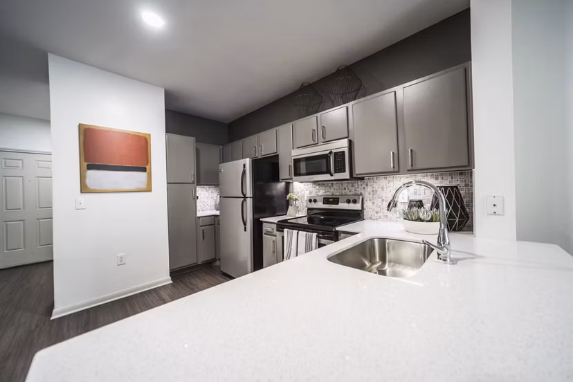 Modern kitchen with sleek appliances and quartz countertops in Muse at SoCo Apartments