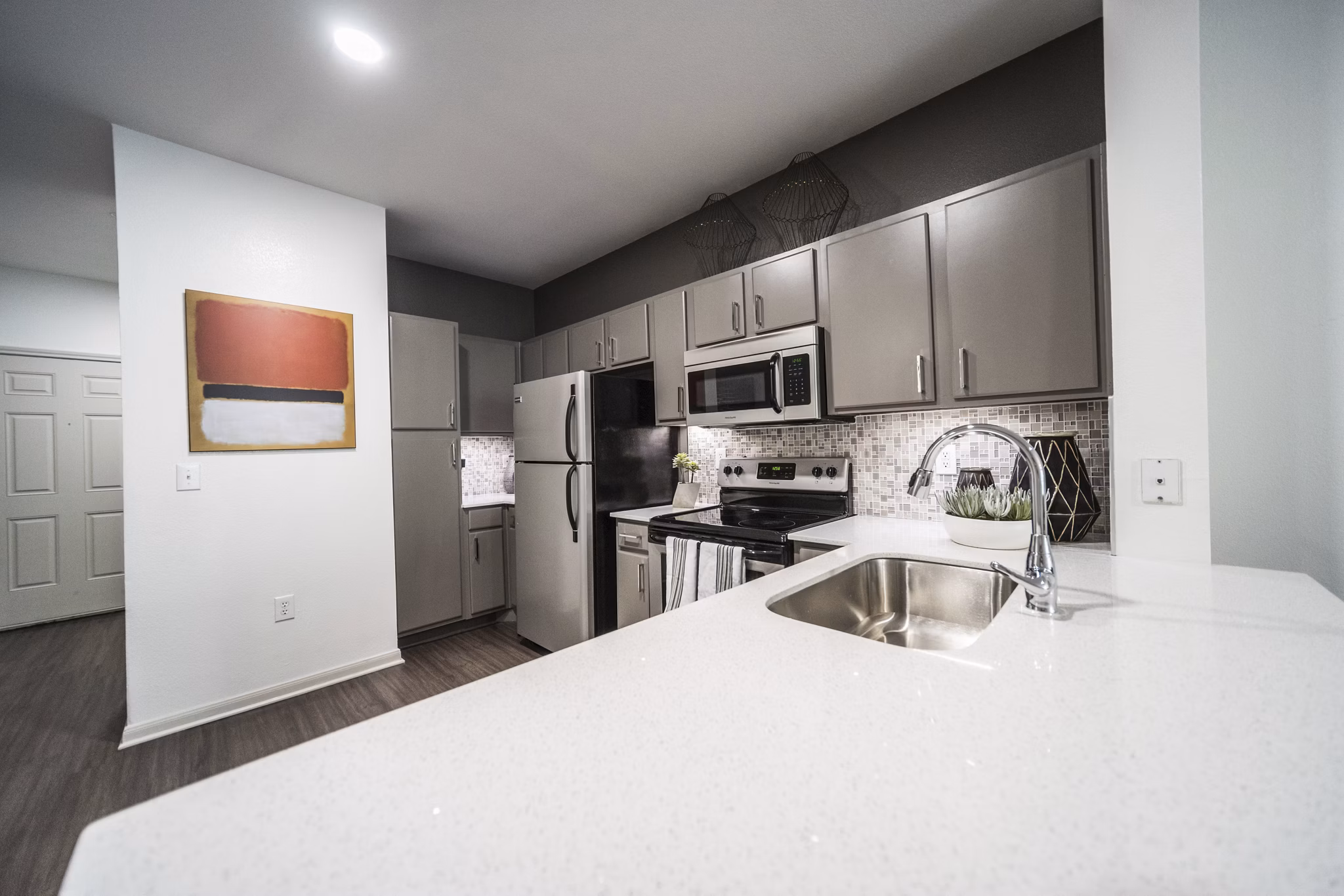 Modern kitchen with sleek appliances and quartz countertops in Muse at SoCo Apartments