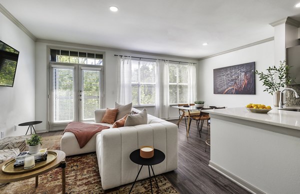 Contemporary living room with stylish decor and large windows at Muse at SoCo Apartments