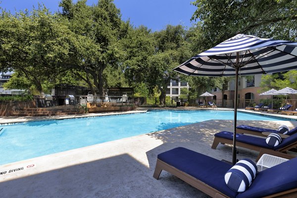 Outdoor pool surrounded by lush landscaping at Muse at SoCo Apartments, offering a luxurious retreat for residents