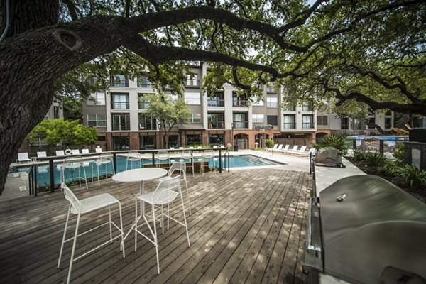 Outdoor grill area with modern seating at Muse at SoCo Apartments, ideal for social gatherings and BBQs