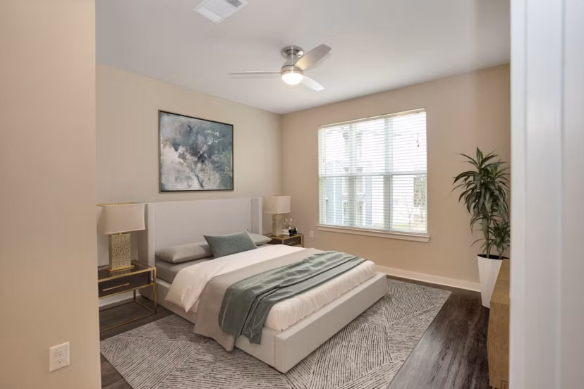 Modern bedroom with king-size bed and large windows in Hays Park Apartments