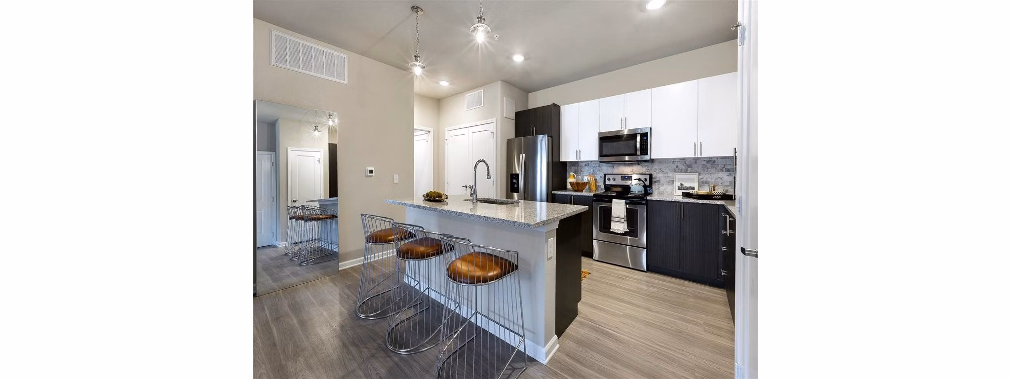 Modern kitchen with granite countertops and stainless steel appliances in Wells Park Apartments