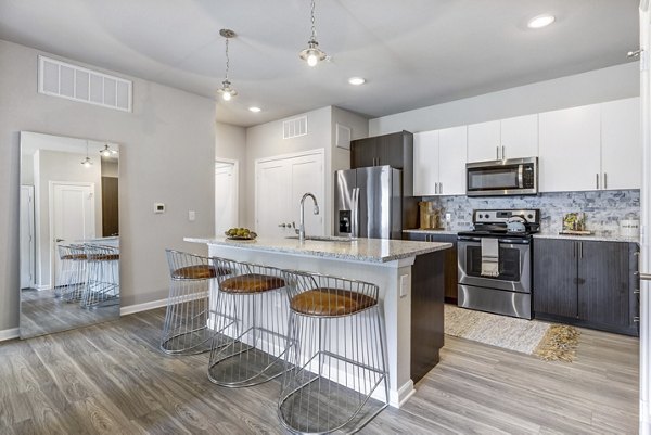 Modern kitchen with stainless steel appliances in Wells Park Apartments