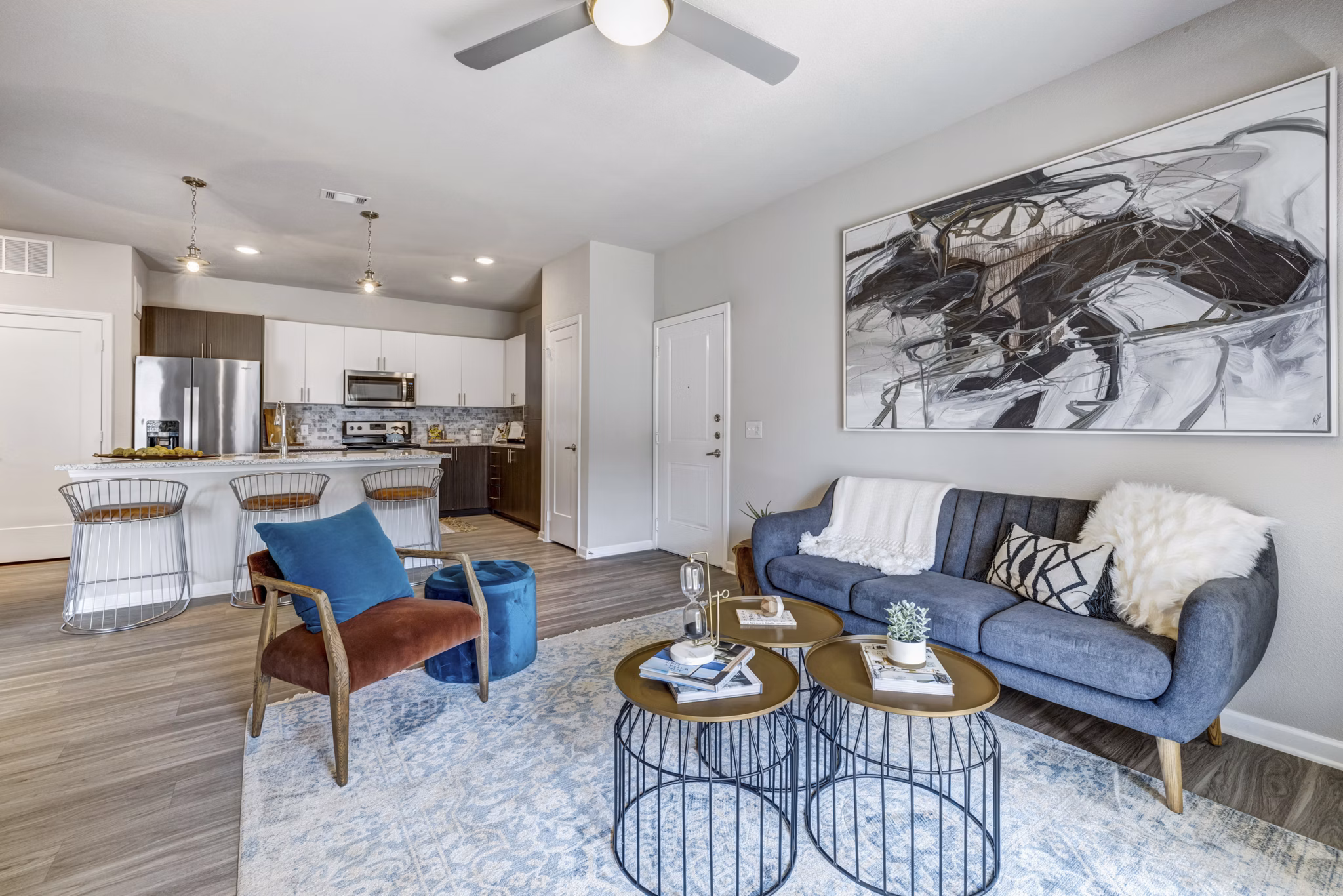 Living room featuring modern decor and abundant natural light at Wells Park Apartments
