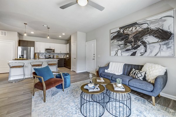 Living room featuring modern decor and abundant natural light at Wells Park Apartments