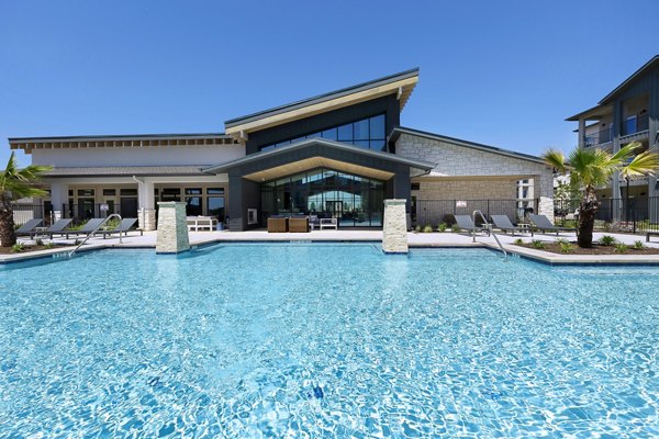 Outdoor swimming pool surrounded by palm trees at luxury apartments in a modern setting