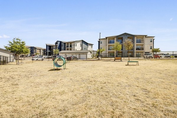 Outdoor recreational area with lush greenery at Wells Park Apartments, featuring spacious seating and walking paths for leisure and relaxation