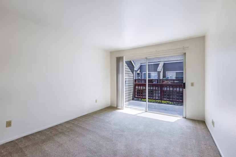 Cozy bedroom with large windows at Wood Creek Apartments
