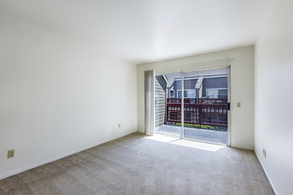 Cozy bedroom with large windows at Wood Creek Apartments