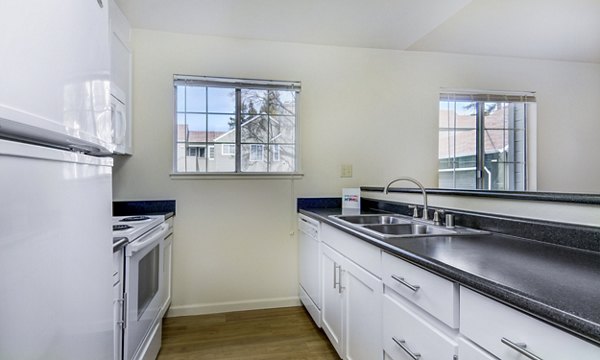 Modern kitchen with stainless steel appliances and granite countertops in Wood Creek Apartments