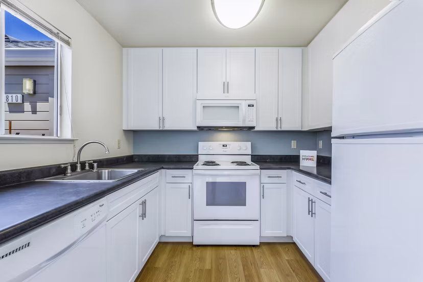 Modern kitchen featuring stainless steel appliances and granite countertops at Wood Creek Apartments