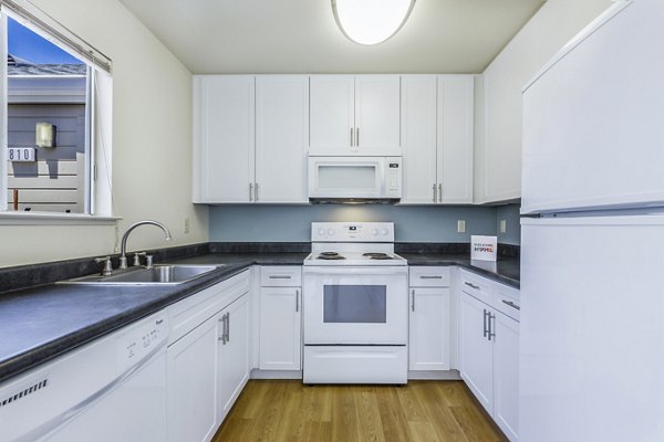 Modern kitchen featuring stainless steel appliances and granite countertops at Wood Creek Apartments