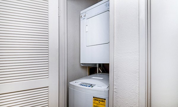 Laundry room with modern appliances at Wood Creek Apartments, a Greystar luxury community