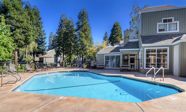 Relax by the serene swimming pool at Wood Creek Apartments, featuring lush surroundings and comfortable lounging areas