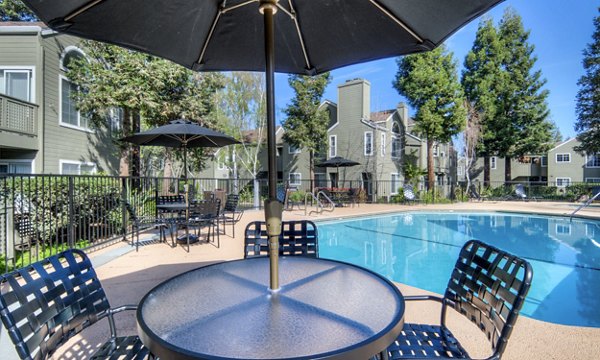 Pool and patio area with lounge chairs at Wood Creek Apartments, offering luxury outdoor relaxation for residents