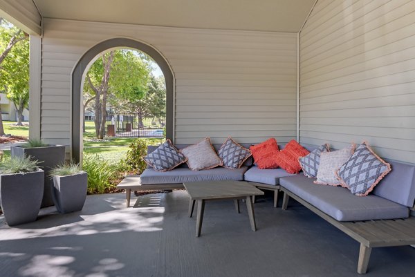 Patio space featuring cozy seating and lush greenery at Vue at Spring Creek Apartments