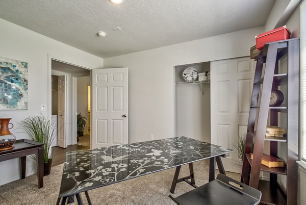 Bedroom with modern furnishings and large windows at Monarch Meadows Apartments