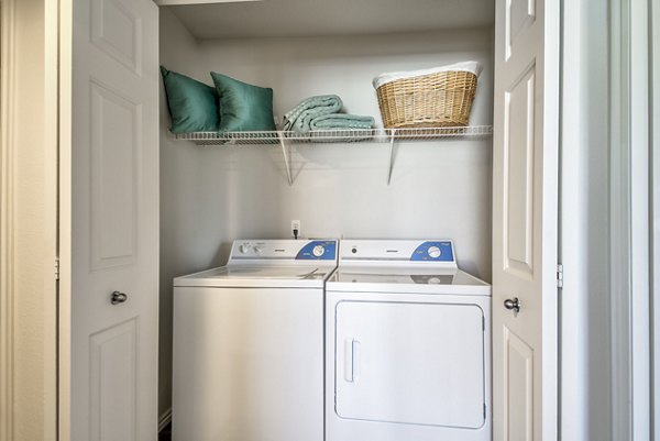 Modern laundry room with high-efficiency washers and dryers at Monarch Meadows Apartments