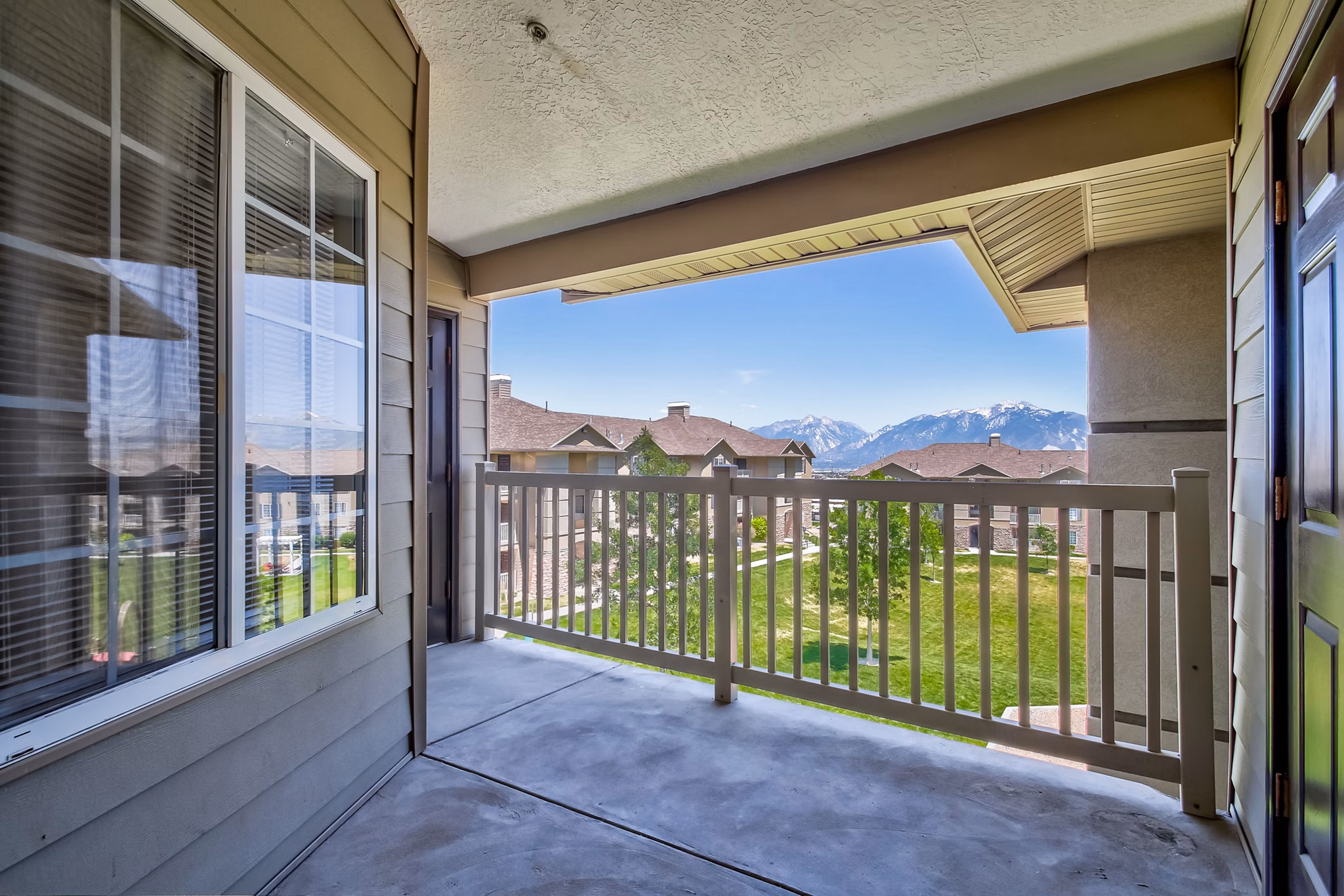 Sunny outdoor patio at Monarch Meadows Apartments with comfortable seating and lush greenery, perfect for relaxation and gatherings