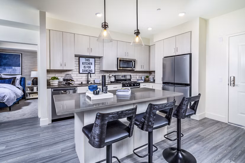 Modern kitchen with granite countertops and stainless steel appliances at The Residences at Cota Vera Apartments Luxury living at its finest