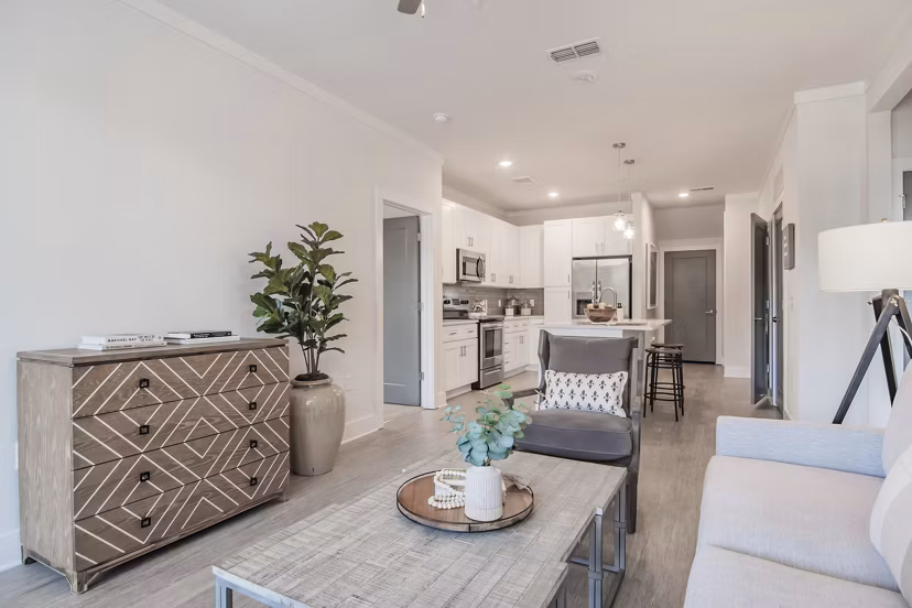 Living room featuring modern design with large windows at The Heron at River Island Apartments