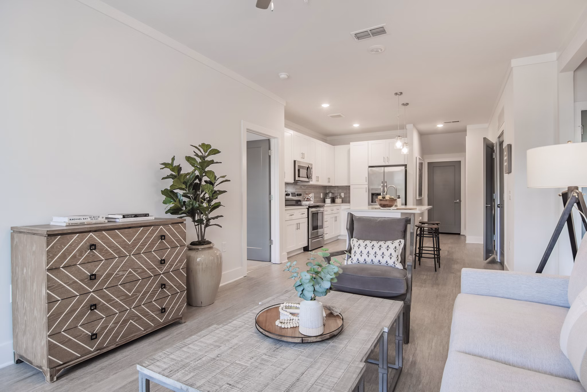 Living room featuring modern design with large windows at The Heron at River Island Apartments