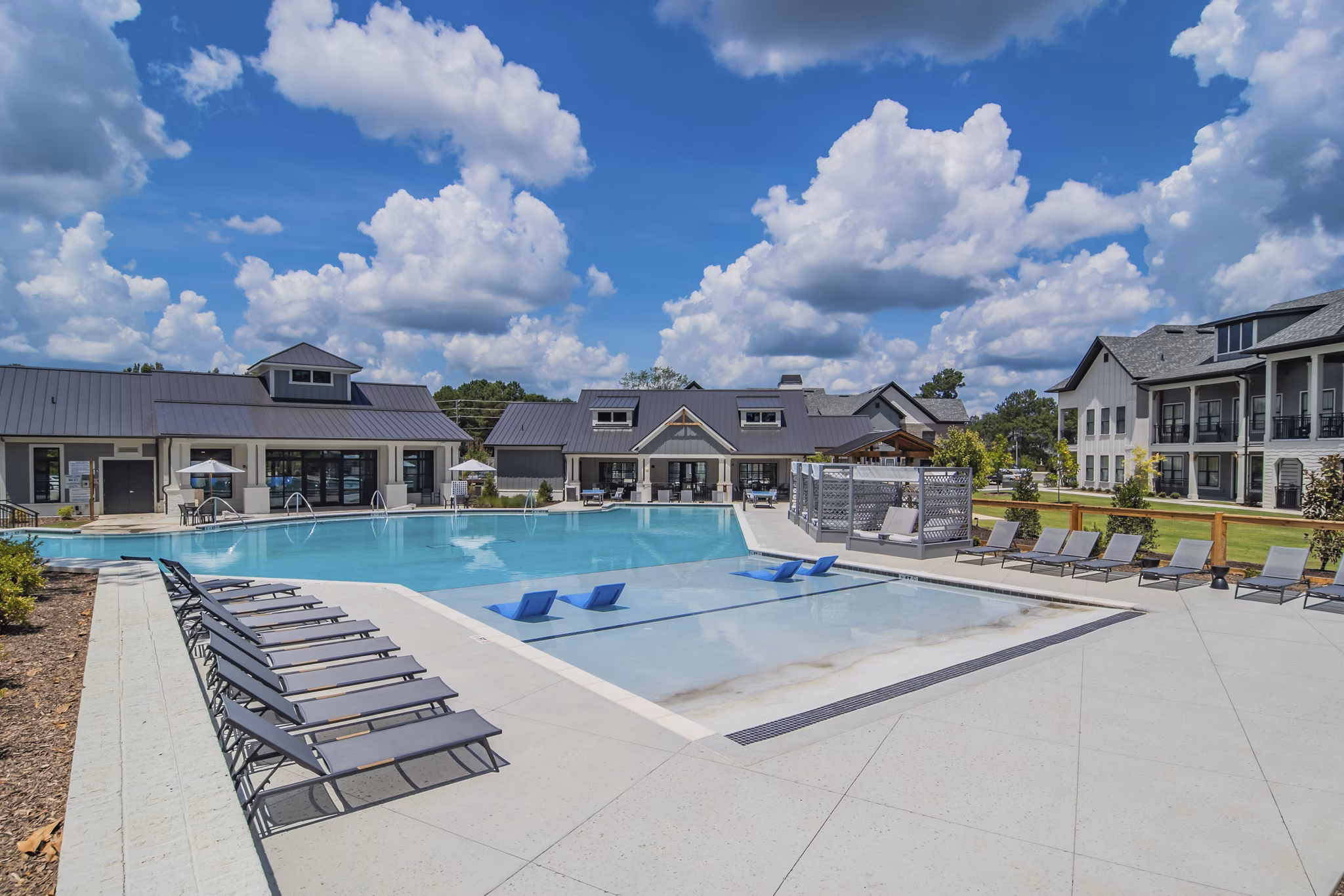 Luxurious outdoor pool with lounge seating at The Heron at River Island Apartments, ideal for relaxation and leisure activities