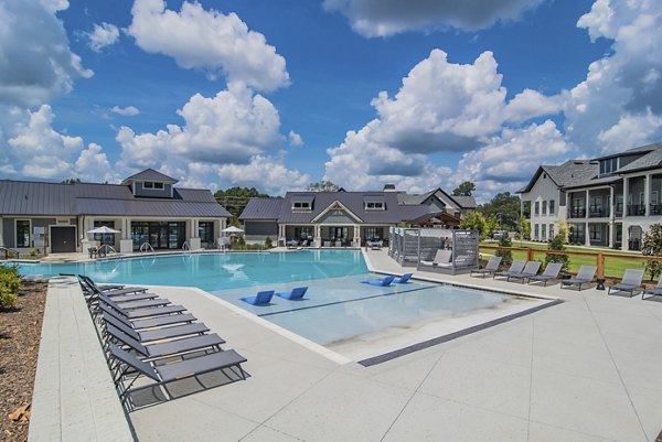 Luxurious outdoor pool with lounge seating at The Heron at River Island Apartments, ideal for relaxation and leisure activities