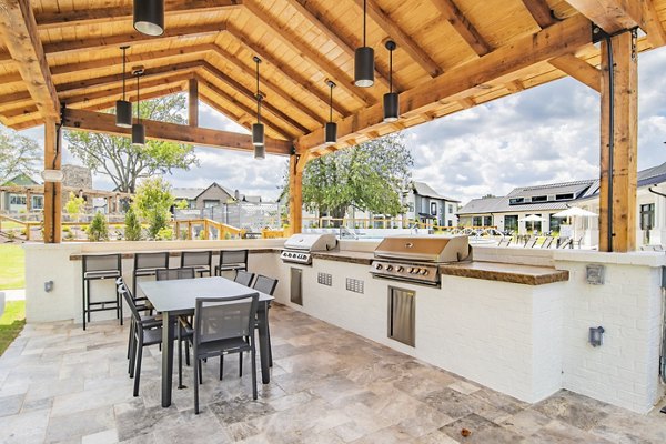Modern outdoor grill area at The Heron at River Island Apartments, featuring sleek BBQ stations and cozy seating for social gatherings