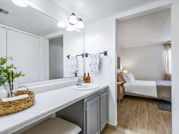 Cozy bedroom with modern furnishings at Parc at 21st & Rock Apartments, luxury living by Greystar