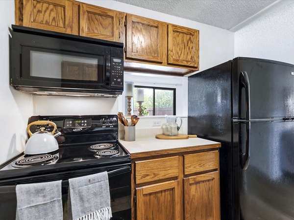 Modern kitchen with stainless steel appliances at Parc at 21st & Rock Apartments, showcasing luxury living in a Greystar community