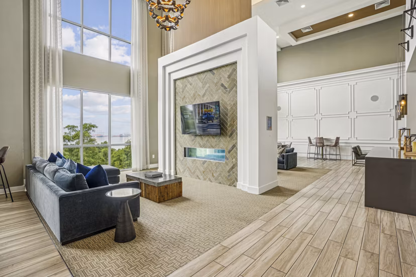 Clubhouse at Liberty Bay Club Apartments: Modern lounge with plush seating and large-screen TV, perfect for social gatherings and relaxation