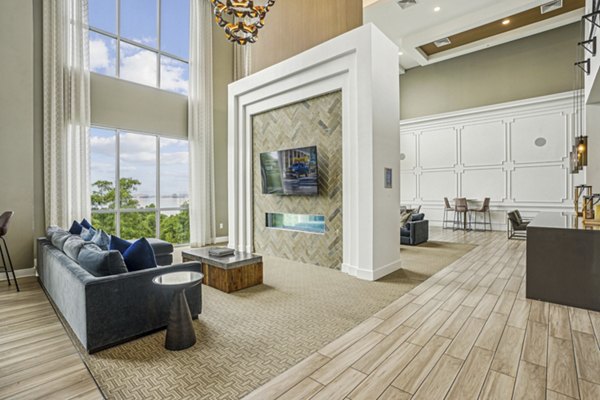 Clubhouse at Liberty Bay Club Apartments: Modern lounge with plush seating and large-screen TV, perfect for social gatherings and relaxation