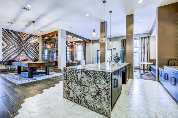 Modern living room with a kitchen island, pendant lights, and a pool table in luxury apartments