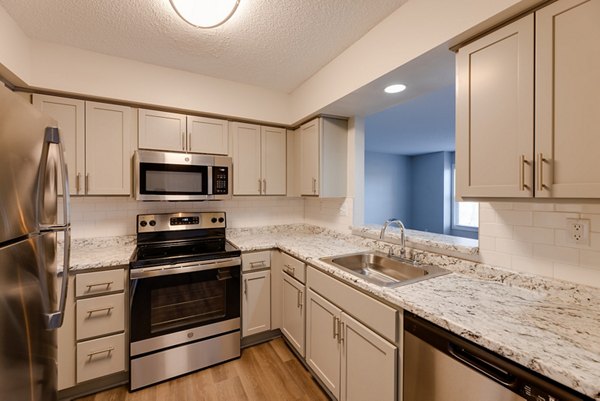 Modern kitchen with stainless steel appliances and island in Wellington Apartments