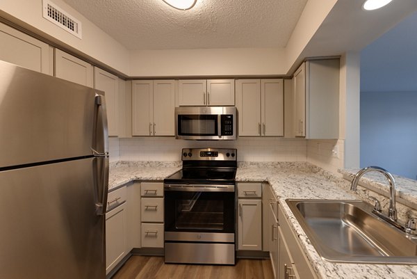 Modern kitchen with stainless steel appliances in Wellington Apartments