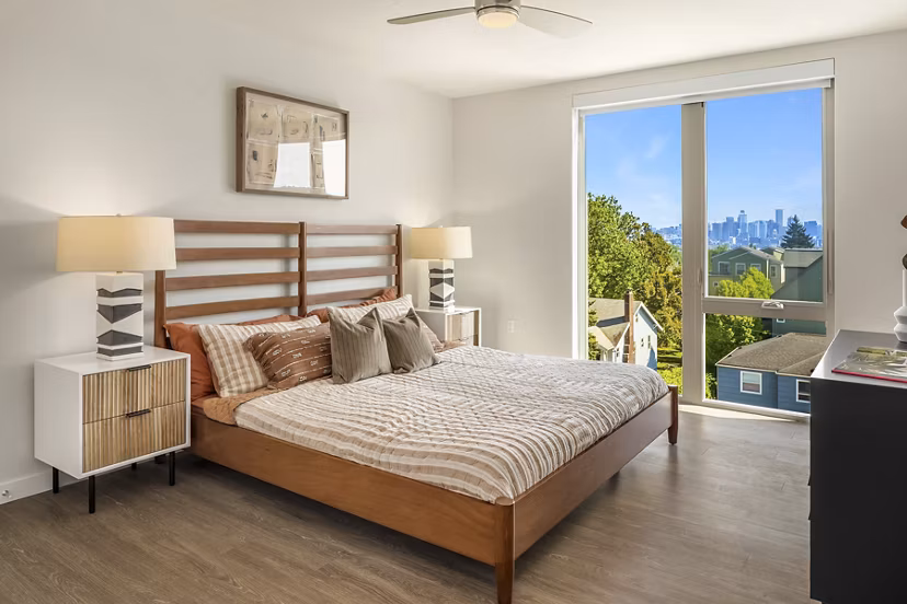 Cozy bedroom with modern decor at Broadstone Vin Apartments, featuring plush bedding and large windows for natural light